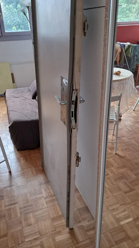 Serrure encastrée et chant de porte endommagés après effraction